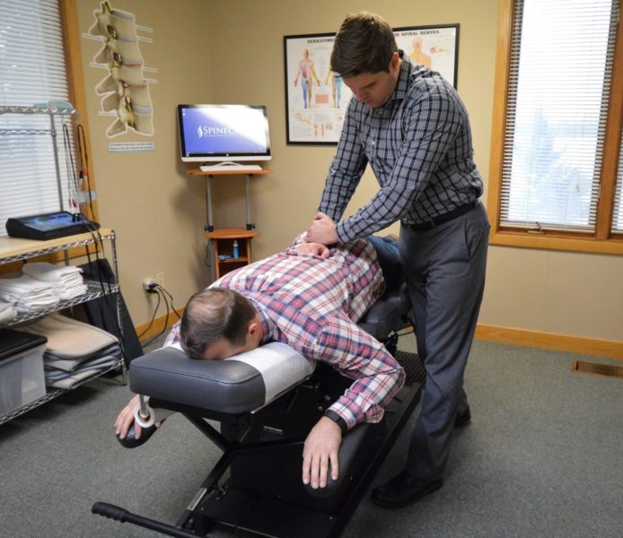 Dr. Rowe giving back pain chiropractic adjustment
